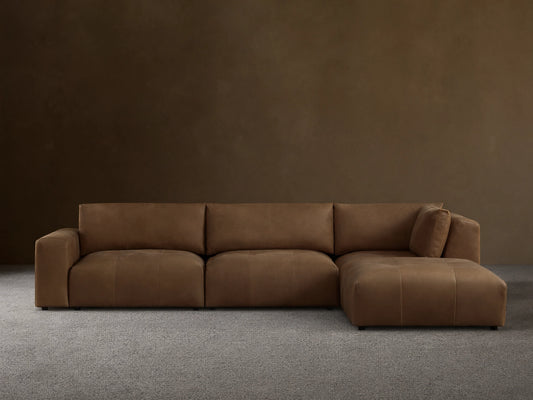 Keegan Leather Four-Piece Sectional in rich brown leather, features a left-facing chaise, three cushioned seats, and wide armrests on a wooden floor.