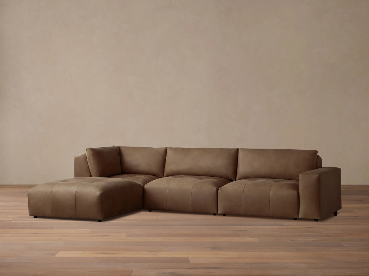 Keegan Leather Four-Piece Sectional in rich brown leather, features a left-facing chaise, three cushioned seats, and wide armrests on a wooden floor.
