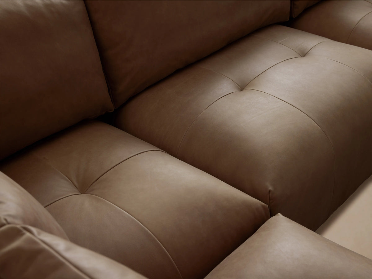 Brown Keegan Leather Four-Piece Sectional in a modern living space, featuring plush cushions and a left-facing chaise on a wooden floor.