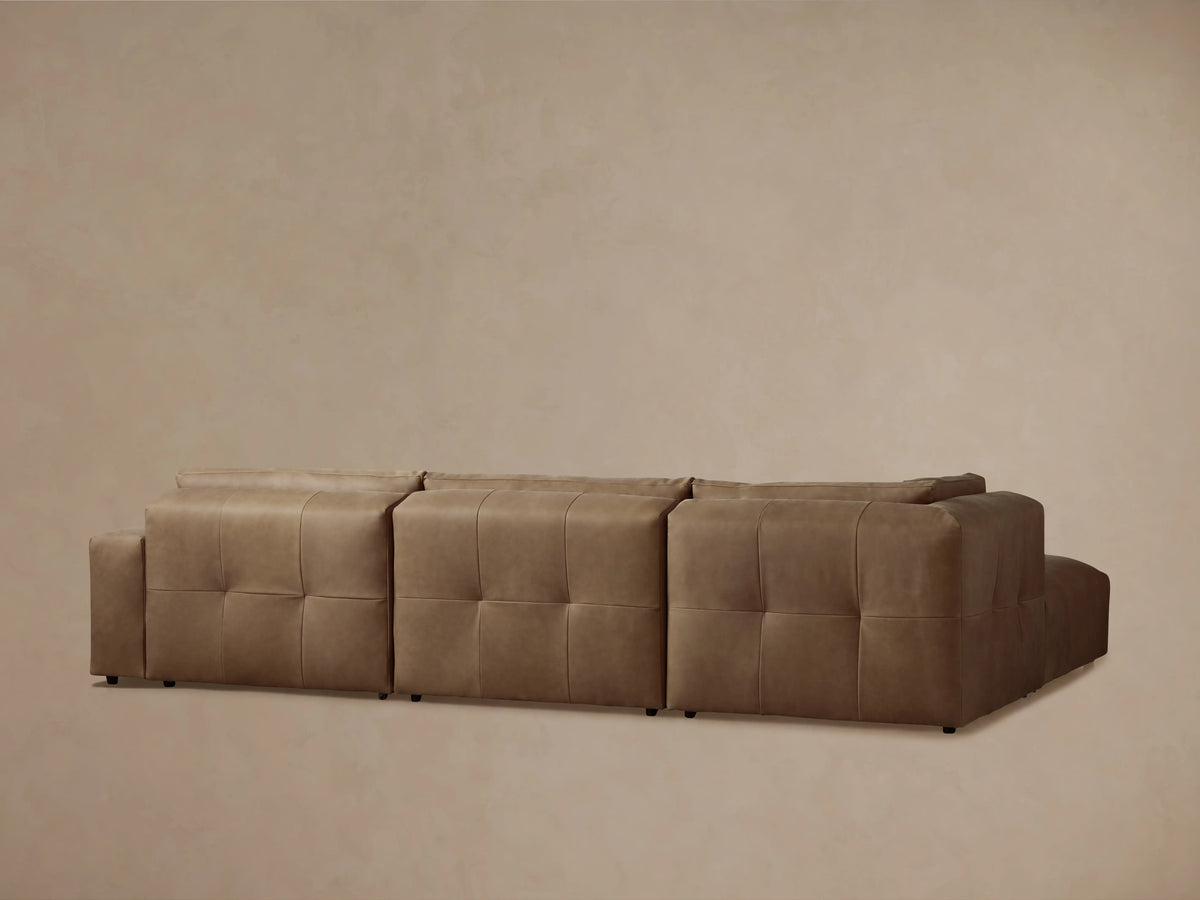 Keegan Leather Four-Piece Sectional in brown leather, showcasing tufted seat detail and smooth back cushions in close-up view.
