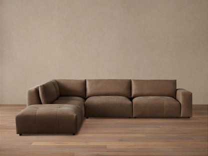 Keegan Leather Five-Piece Sectional in brown leather, L-shaped, with cushiony seat and backrest on wooden floor against a neutral wall.