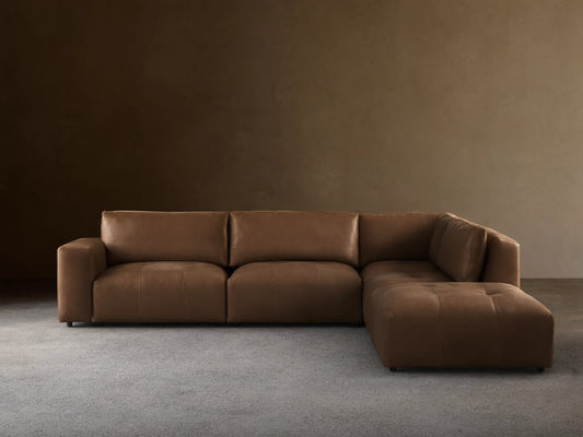 Keegan Leather Five-Piece Sectional in brown leather, L-shaped, with cushiony seat and backrest on wooden floor against a neutral wall.