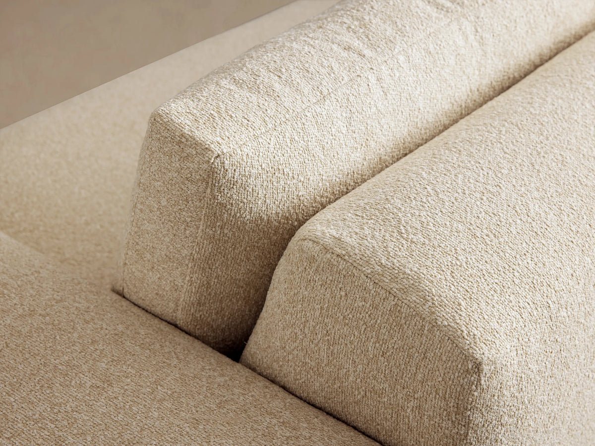 Keegan Tailored Sofa. Modern off-white textured fabric sofa with sharp block arms and two plush back cushions, on wood floor.