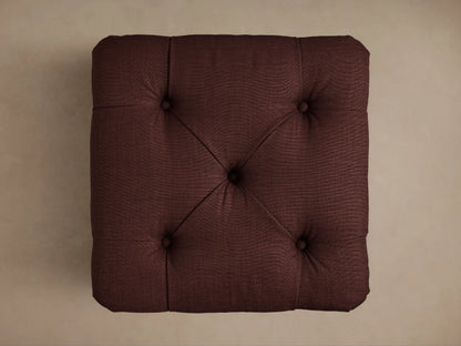 Burgundy Liddie Square Ottoman with a tufted top and a pleated skirted base, shown from an angled view.