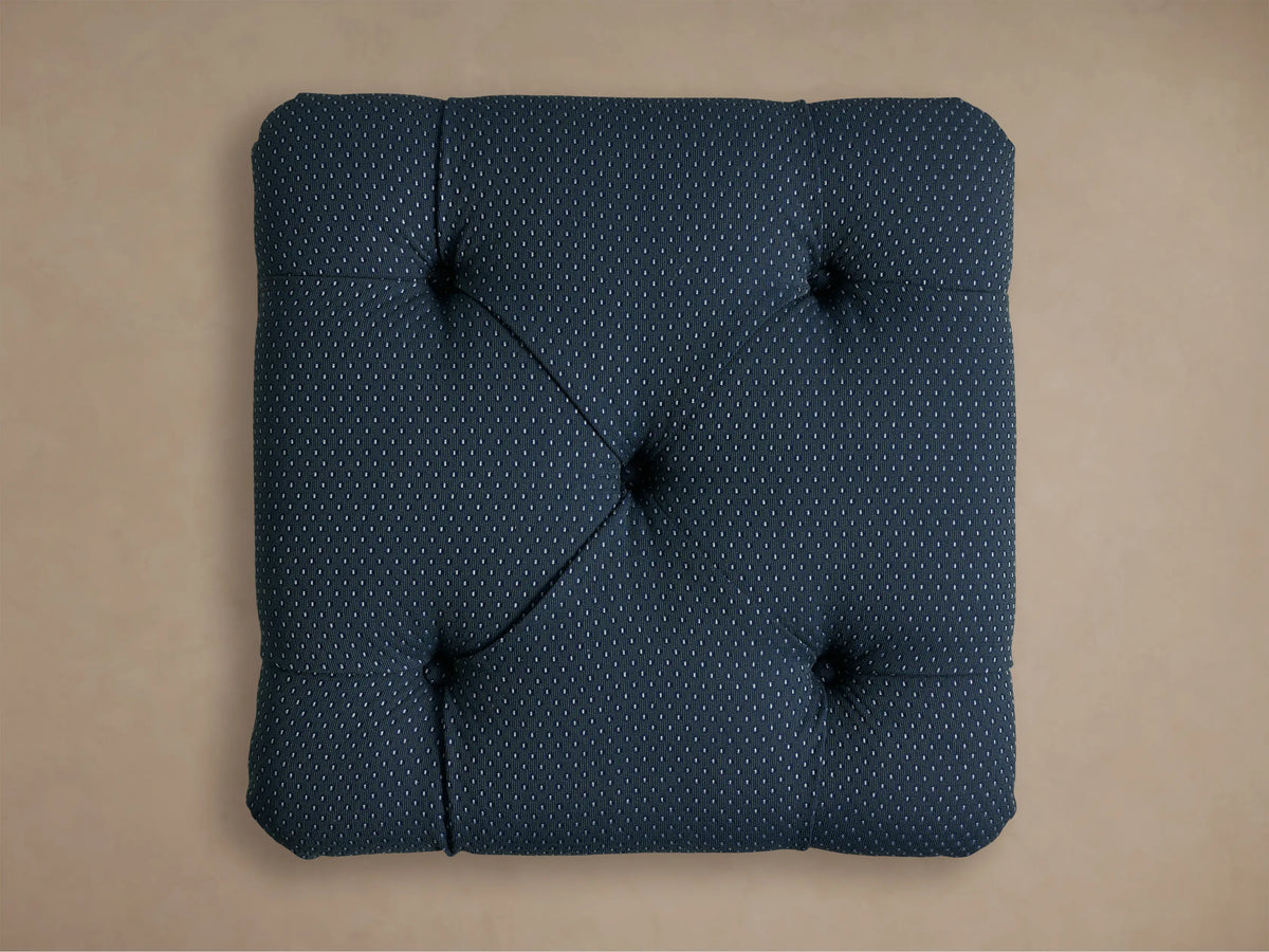 Close-up of the deep blue-green dotted fabric on the Liddie Square Ottoman, showing a tufted detail.