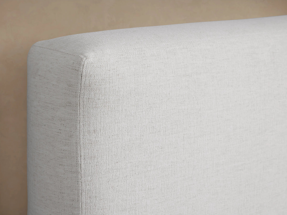 The image shows a close-up of the Lago Bed headboard, upholstered in light beige fabric. The fabric appears soft and textured.