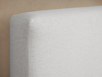 The image shows a close-up of the Lago Bed headboard, upholstered in light beige fabric. The fabric appears soft and textured.