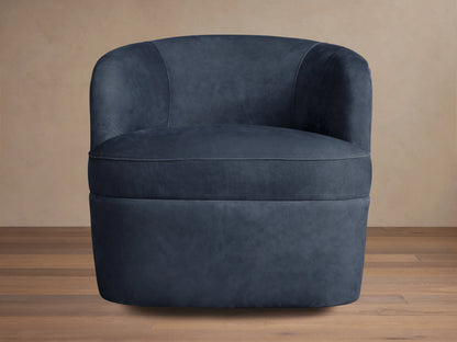 Dark blue nubuck leather swivel chair with rounded back and plush seat, angled slightly right on a wooden floor.