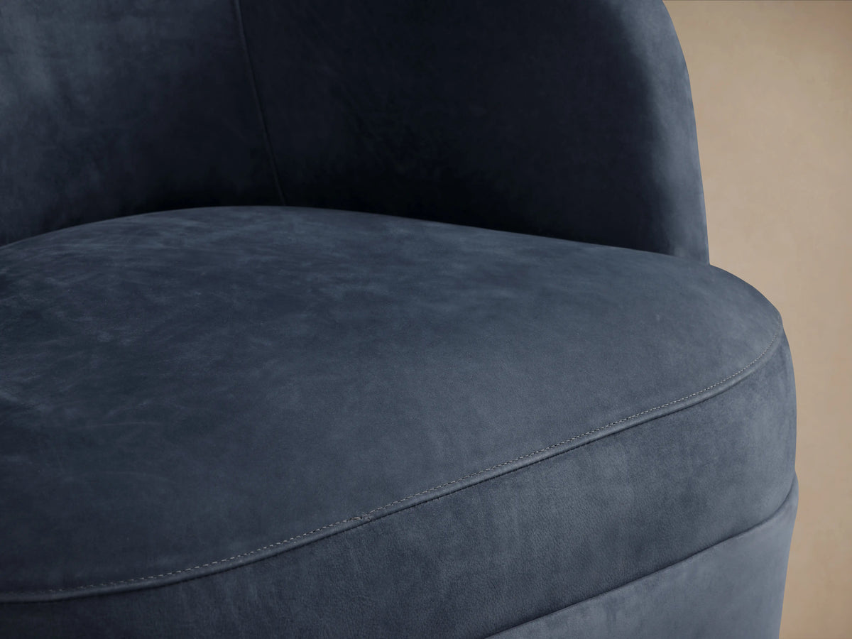 Front view of Mercer Nubuck Leather Swivel Chair. Dark blue, velvety nubuck leather, curved back, plump seat on wood floor.