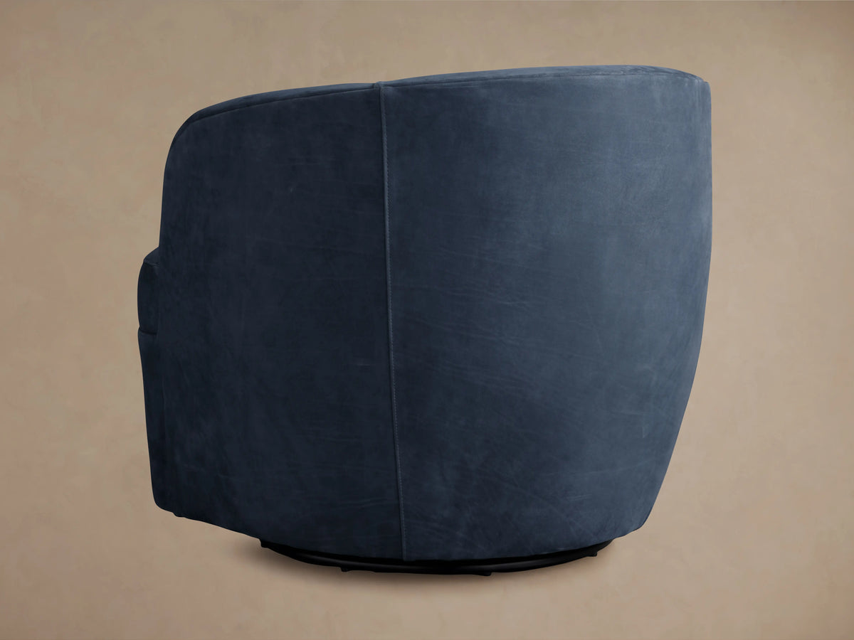 Close-up of a navy blue Mercer Nubuck Leather Swivel Chair, highlighting its velvet-like texture and detailed seat stitching.