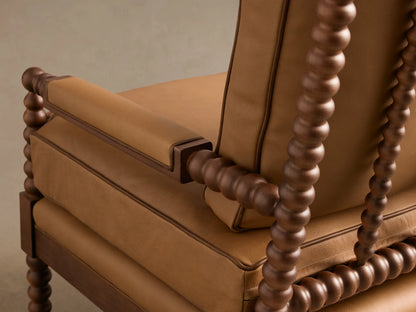 Close-up of the light brown Milly Leather Chair, showing the armrest and side frame with dark wood spindled details.