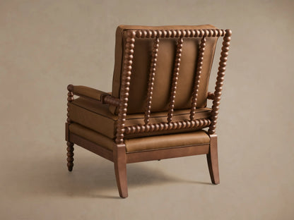 Front-quarter view of the brown Milly Leather Chair, showcasing its spindled dark wood arms and legs and plush upholstered cushions.