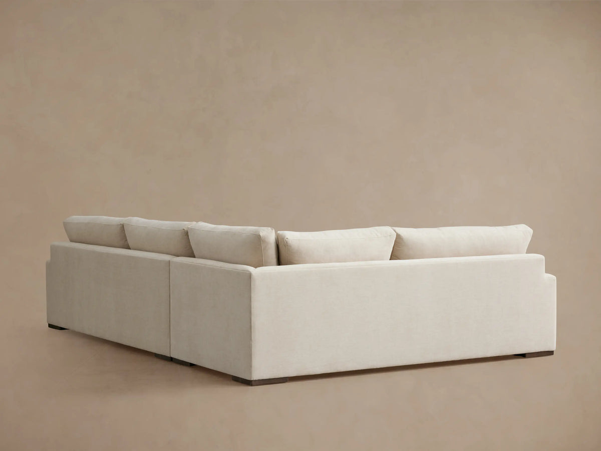 Norwalk Two-Piece Sectional in light beige fabric. Features plush backrests and seat cushions. Positioned on a neutral backdrop.