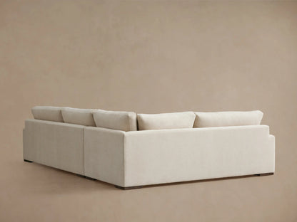 Norwalk Two-Piece Sectional in light beige fabric. Features plush backrests and seat cushions. Positioned on a neutral backdrop.
