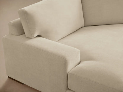 A beige Norwalk Two-Piece Cuddle Chaise Sectional with plush cushions, left-arm chaise, and right-arm sofa on a wooden floor.