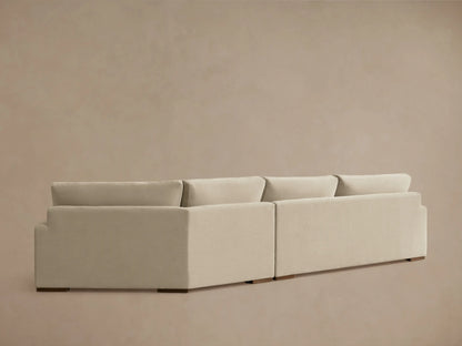Beige Norwalk Two-Piece Cuddle Chaise Sectional with plush cushions. Features smooth fabric, wide armrest, and a corner setup.