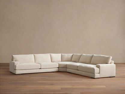 Norwalk Three-Piece Corner Wedge Sectional in beige fabric. L-shaped design on wooden floor, against a light brown wall.