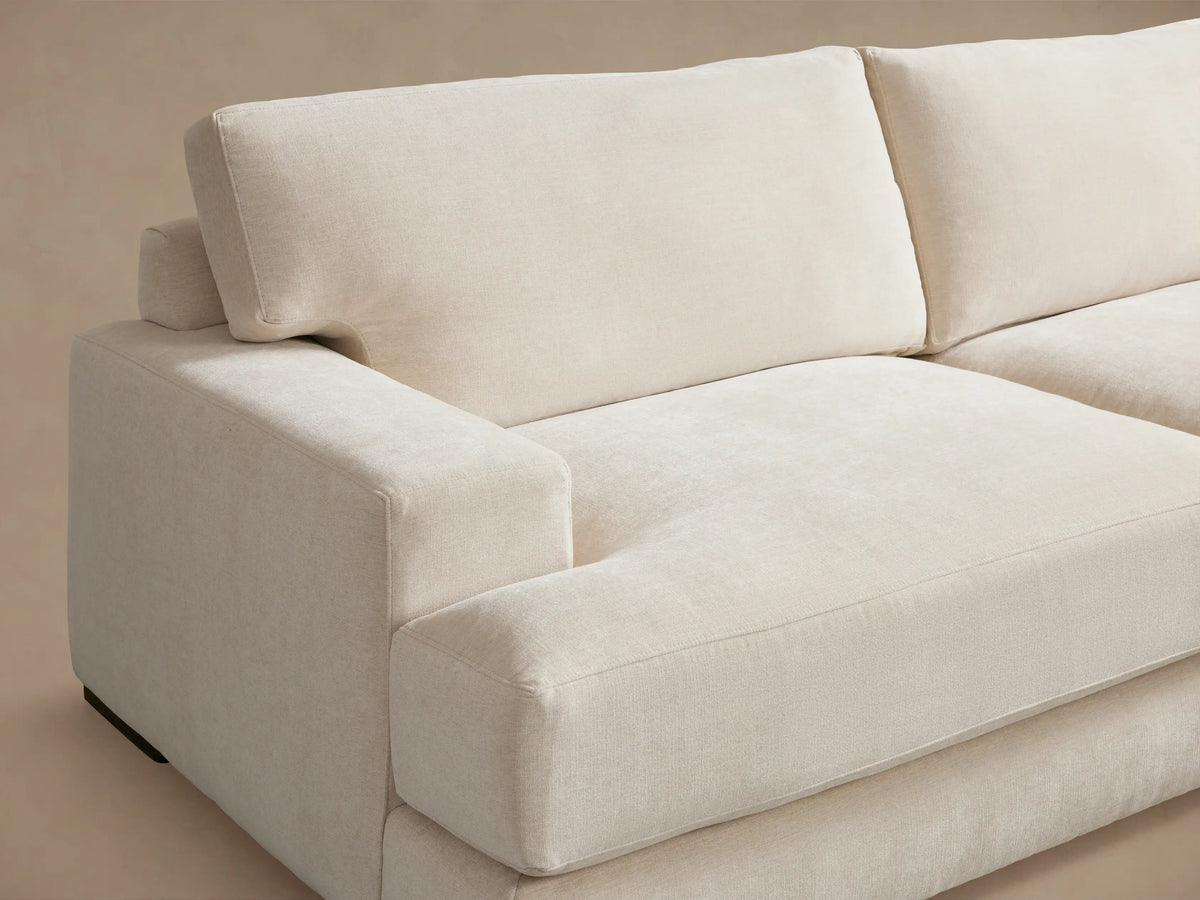 Beige Norwalk Three-Piece Corner Wedge Sectional on wood floor, featuring plush cushions and a modern design against a neutral background.