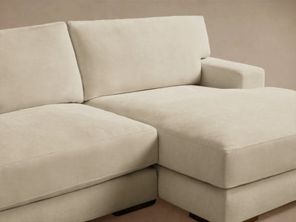 Norwalk Two-Piece Chaise Sectional in light beige fabric, featuring a left-arm sofa and right-arm chaise on wooden floor. Neutral wall backdrop.