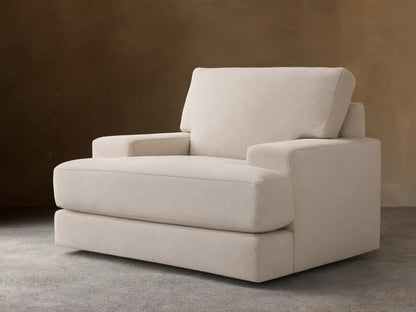Cream-colored Norwalk Swivel Chair with plush seat and backrest, thick armrests, set on wooden floor against a beige wall.