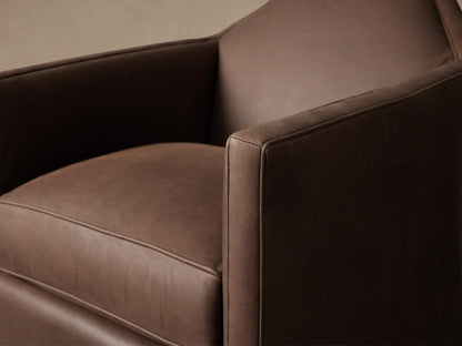 Marina Leather Swivel Chair: Dark brown leather, boxy shape, plush seat cushion, front view, on wood floor.