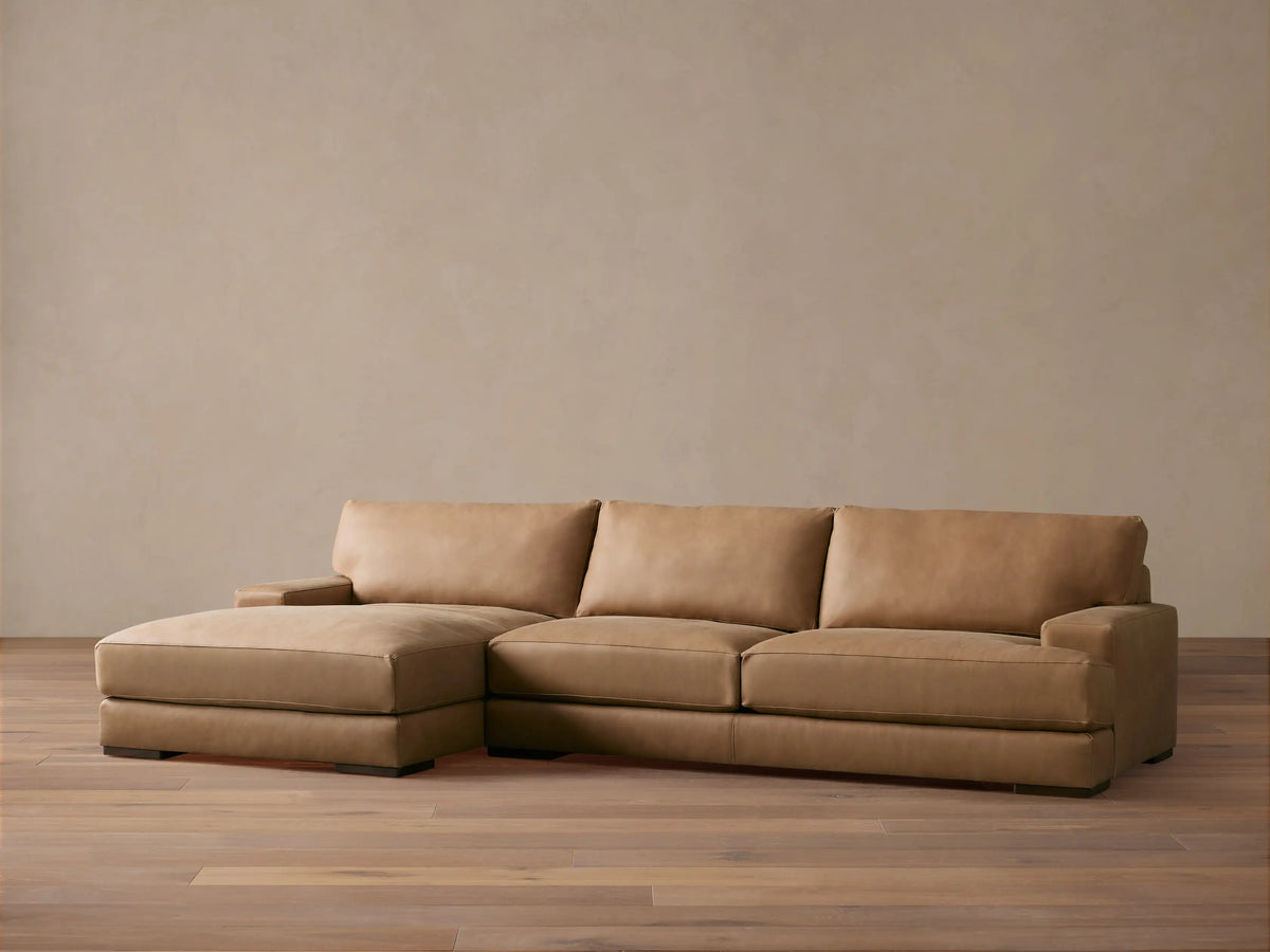 Norwalk Leather Two-Piece Chaise Sectional in tan leather; chaise on left, three back cushions, sleek and contemporary design on wooden floor.