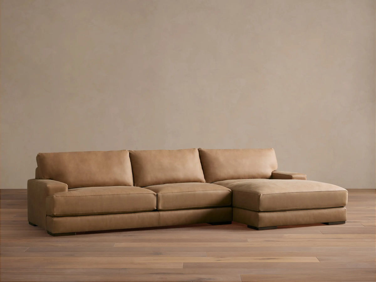 Norwalk Leather Two-Piece Chaise Sectional in tan leather, features three-seat sofa with right-facing chaise, set on light wood floor.