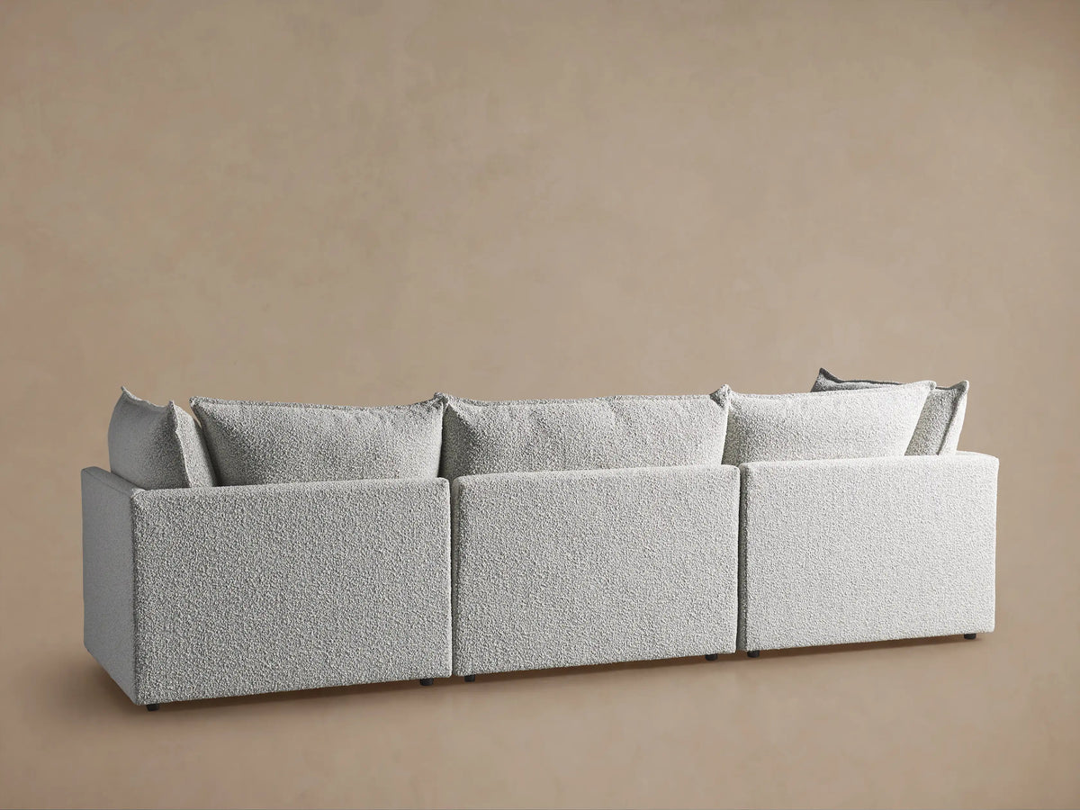 Close-up of Owen Three-Piece Modular Sofa, showing plush, textured light grey fabric on cushions and armrest.