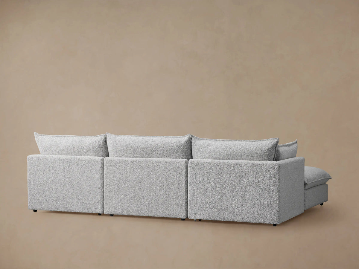 Close-up of Owen Four-Piece Sectional in Burbank Pepper, showing textured gray fabric on cushions, armrest, and throw pillow.