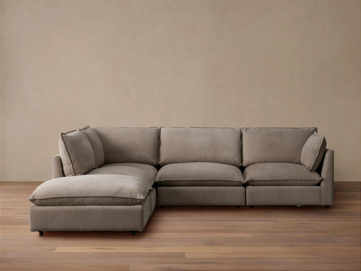 Owen Nubuck Leather Five-Piece Sectional, L-shaped, soft taupe, plush cushions, on a wood floor, tan wall background.