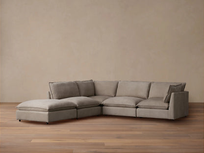 Owen Nubuck Leather Five-Piece Sectional, L-shaped, soft taupe, plush cushions, on a wood floor, tan wall background.