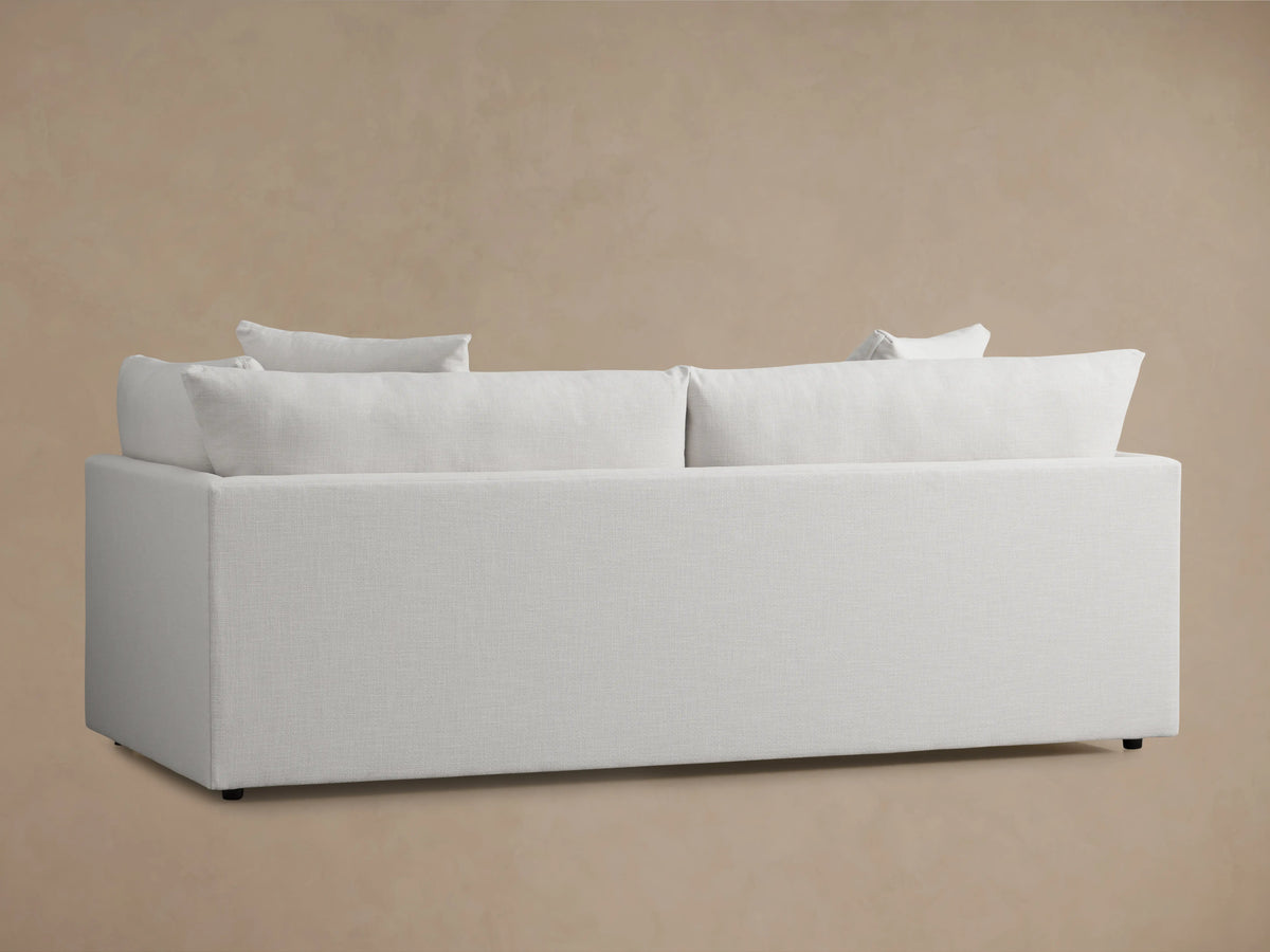 Pavo Sofa in Barbados Cream, back view. Features plush, full-length back cushions, and a minimalist rectangular frame against a neutral background.