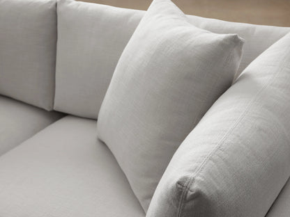 Pavo Sofa in Barbados Cream fabric, with plush cushions and clean lines. Placed on a wooden floor against a neutral wall.