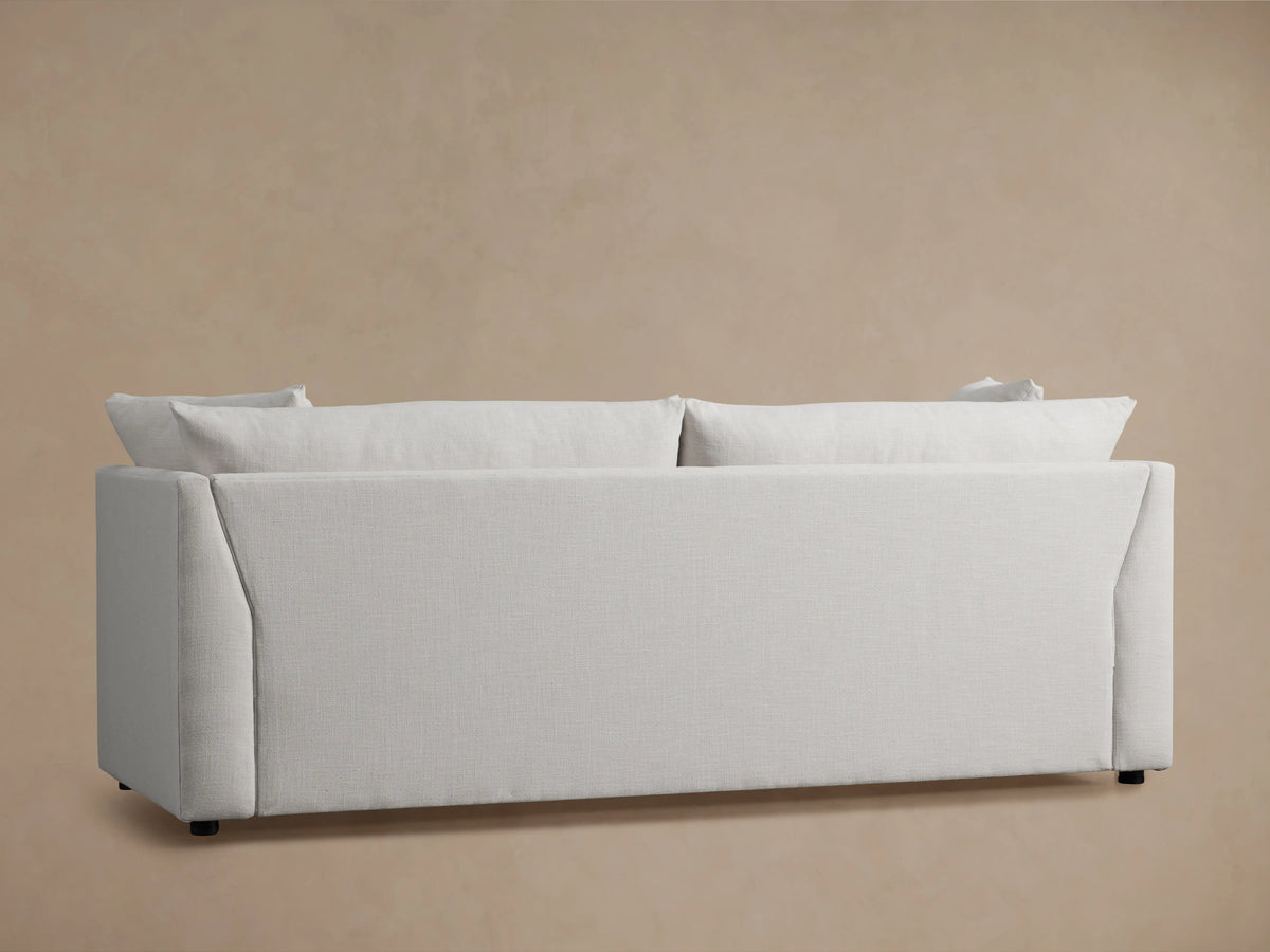 Pavo Trundle Sleeper Sofa in Barbados Cream fabric, featuring plush cushions and a sleek, angled armrest design on a soft beige background.