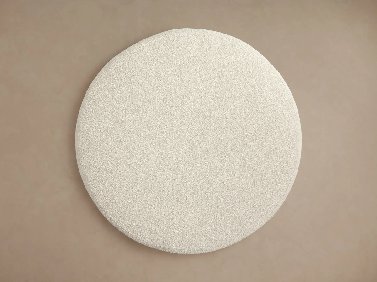 Circular cream-colored Ryles Plinth Ottoman with textured fabric, viewed from above on a neutral background.