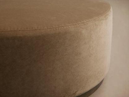 Ryles Plinth Ottoman in beige fabric, close-up view showcasing its round shape and smooth upholstery with visible stitching.