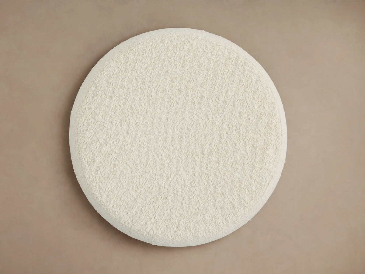 Circular Ryles Plinth Ottoman in a soft, textured, off-white fabric, viewed from above on a neutral background.