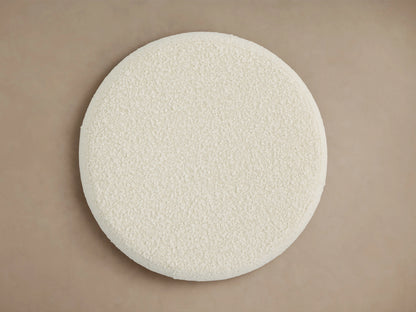 Circular Ryles Plinth Ottoman in a soft, textured, off-white fabric, viewed from above on a neutral background.