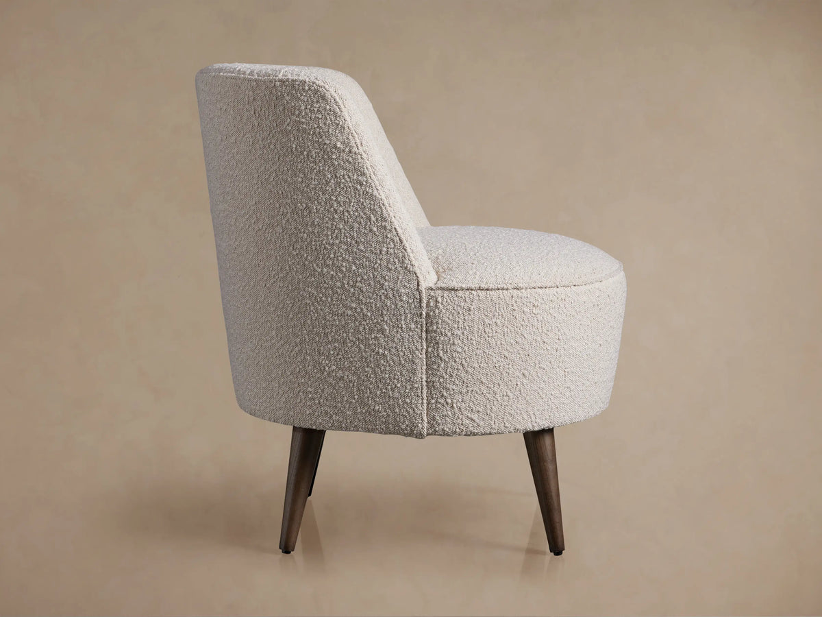 Rear view Ryles Chair. Cream boucle fabric, rounded back, dark brown flared wooden legs on neutral background.