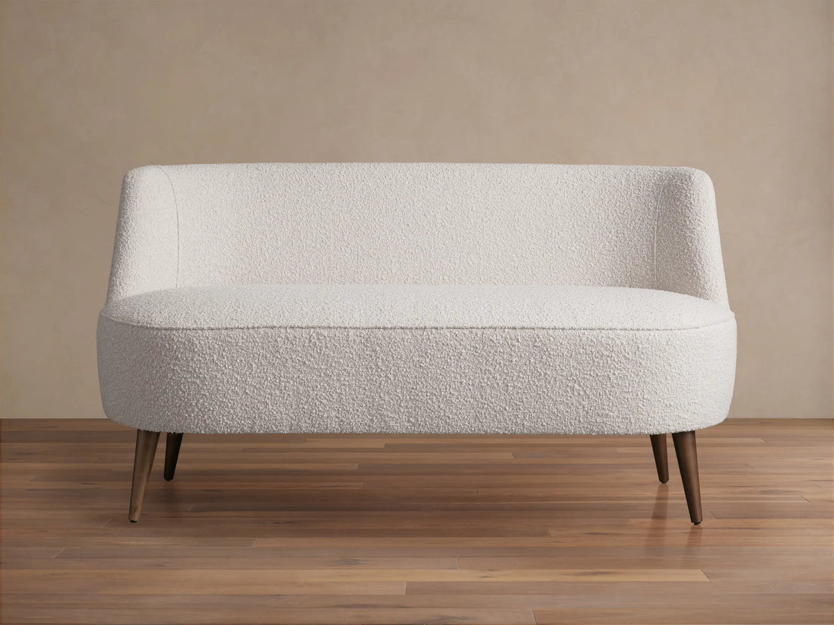 Ryles Tapered Leg Settee: Cream textured fabric, curved back and seat, dark brown tapered wood legs. Centered front view.