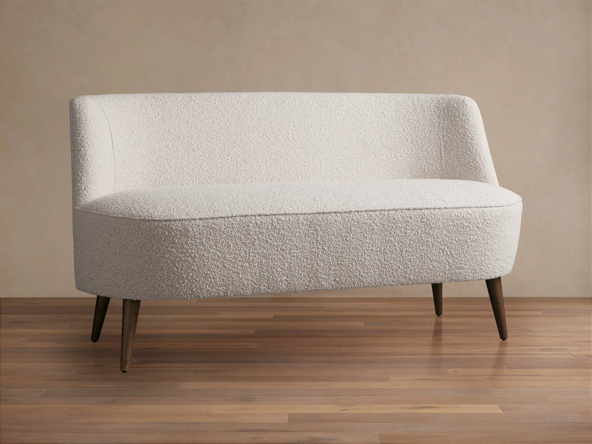 Ryles Tapered Leg Settee: Cream textured fabric, curved back and seat, dark brown tapered wood legs. Centered front view.
