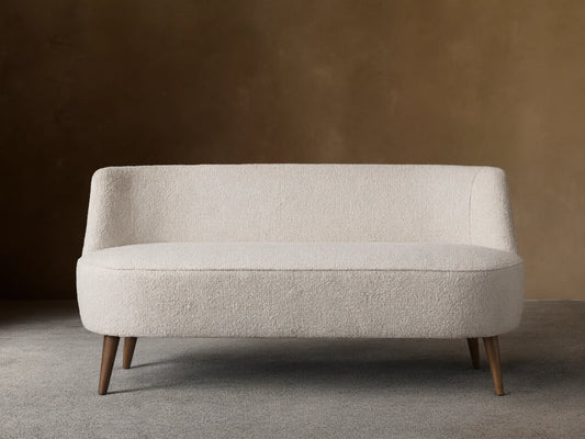 Ryles Tapered Leg Settee: Cream textured fabric, curved back and seat, dark brown tapered wood legs. Centered front view.