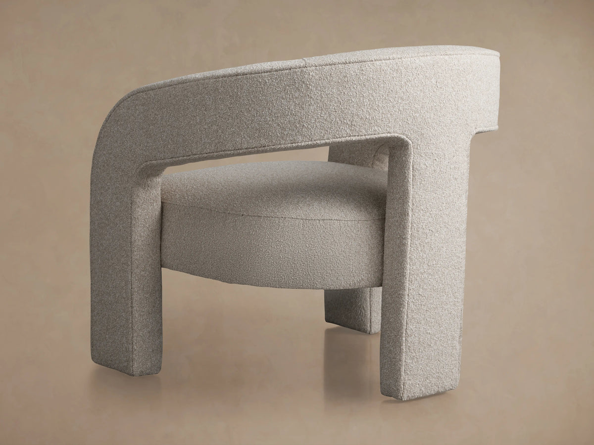 Mara Cutout Chair, light grey textured fabric. Modern, minimalist design with continuous frame for back, arms & legs. Integrated seat, angled.