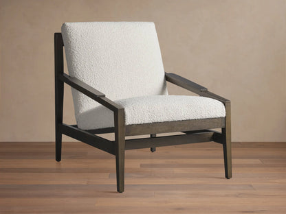 Sarlow Chair, modern design, dark wood frame, and textured off-white upholstery, on a wooden floor against a beige wall.