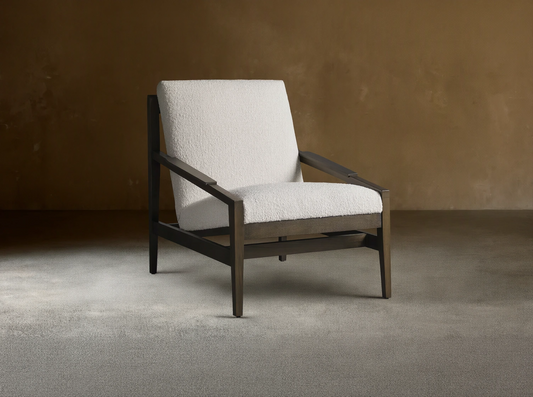 Sarlow Chair, modern design, dark wood frame, and textured off-white upholstery, on a wooden floor against a beige wall.