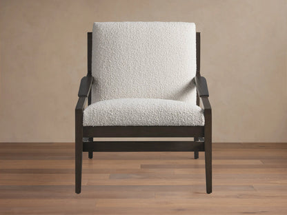 Sarlow Chair, modern design, dark wood frame, and textured off-white upholstery, on a wooden floor against a beige wall.
