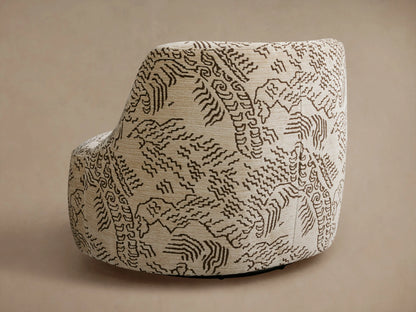 Close-up of a Sonny Swivel Chair upholstered in a beige fabric with intricate dark brown abstract wavy patterns, angled view.