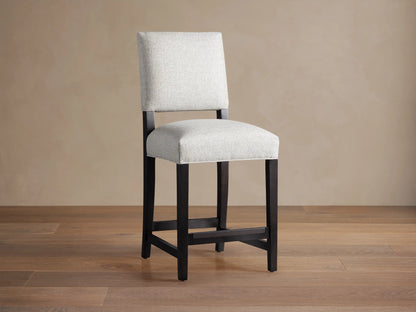 Torino Stool with light grey upholstered seat and back, dark wood frame, standing on a wooden floor.