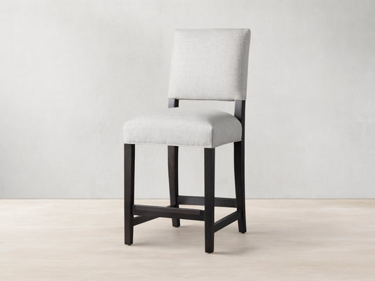 Torino Stool with light grey upholstered seat and back, dark wood frame, standing on a wooden floor.