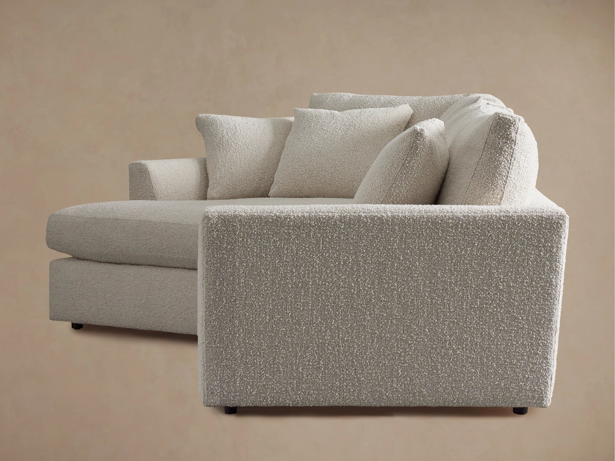 Close-up of Vernon Cuddle Chaise Sectional showing armrest & cushions in textured cream boucle fabric with subtle two-tone design.